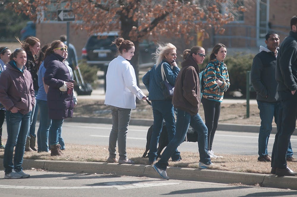 <p>Individuals and animals evacuated watch as the police arrive Mar. 18, 2015 at the Veterinary Medicine Center on 736 Wilson Rd. A natural gas leak was confirmed. Alice Kole/The State News </p>