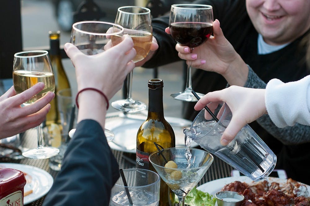 <p>Students enjoy drinks and warm weather April 2, 2014 at Dublin Square. Allison Brooks/The State News</p>