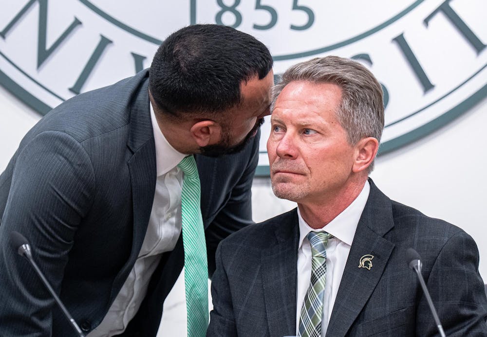 Michigan State University Chief of Staff to the Board of Trustees Stefan Fletcher speaks to President Kevin Guskiewicz following an interruption by protestors at a Board of Trustees meeting at the Hannah Administration Building on Feb. 7, 2025. 