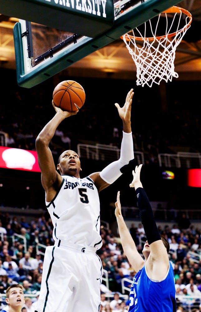 Sophomore guard Adreian Payne goes for the net in spite of Hillsdale forward/center Nick Washburn Friday night at Breslin Center. Payne put up 10 points against the Chargers, helping the Spartans defeat Hillsdale 80-58. Matt Hallowell/The State News