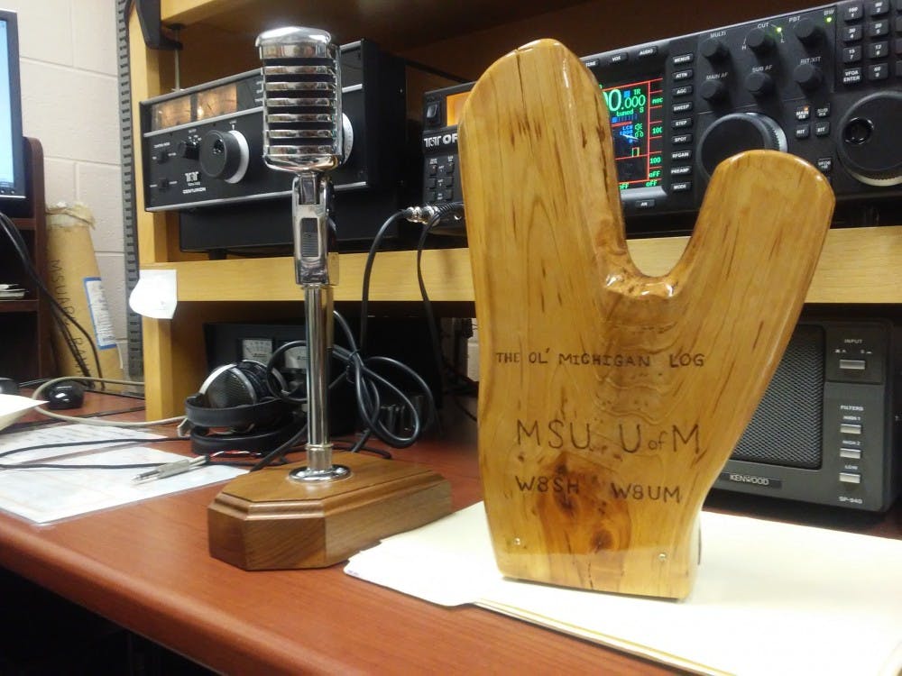 <p>The “Ol’ Michigan Log,” seen here on a desk in MSU’s Amateur Radio Club station, W8MSU. The Log, much like a version of football's Paul Bunyan trophy, is awarded to the winner of a annual radio sport contest between the amateur radio clubs of Michigan State and the University of Michigan. The MSUARC secured the award in 2016.&nbsp;</p>