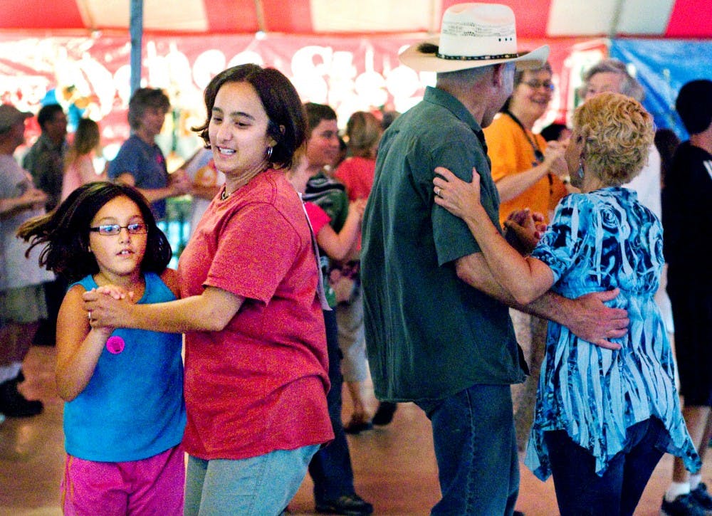 In this photo from Aug. 12, 2011, Lansing residents Katarina, 9, and Tamiko Rothhorn dance with Mason residents Tom and Marla Warren at the Great Lakes Folk Festival. Festival attendees could participate in a variety of dances throughout the day at the Dance Stage. State News File Photo