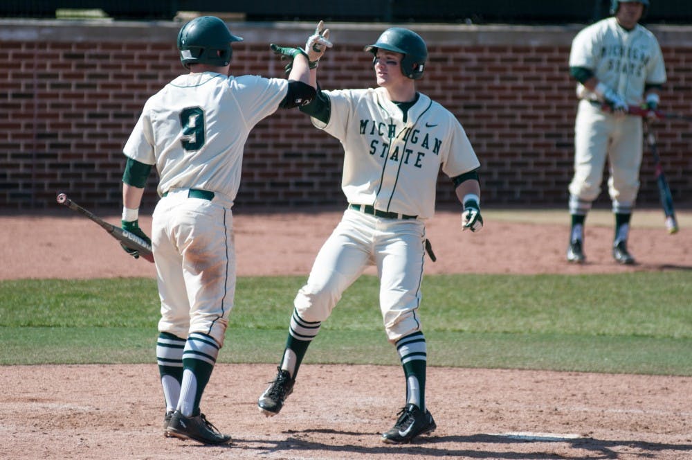 Freshman infielder Marty Bechina, right, and junior infielder Dan Durkin celebrate at home plate during the game against Rutgers on March 27, 2016 at McLane Stadium. The Spartans defeated the Scarlet Knights, 6-5.