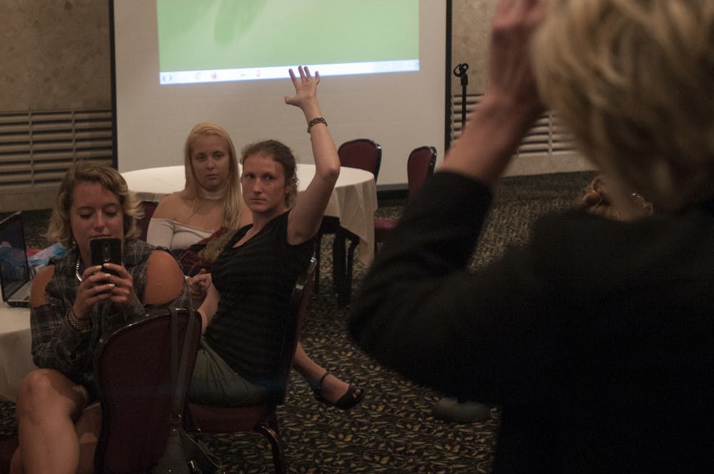 Doctoral student Apryl Pooley, center, raises her hand during a forum on Sept. 6, 2016 in the MSU Union. The forum allowed students to voice their questions and opinions about the closing of the women's study lounge. 