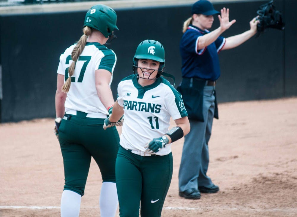 Freshman firstbaseman Riley Paxson (27) celebrates with freshman second baseman Caitie Ladd (11) during the game against Eastern Michigan on April 24, 2018 at Secchia Stadium. The Spartans defeated the Eagles, 9-1 in five innings. (Annie Barker | State News)