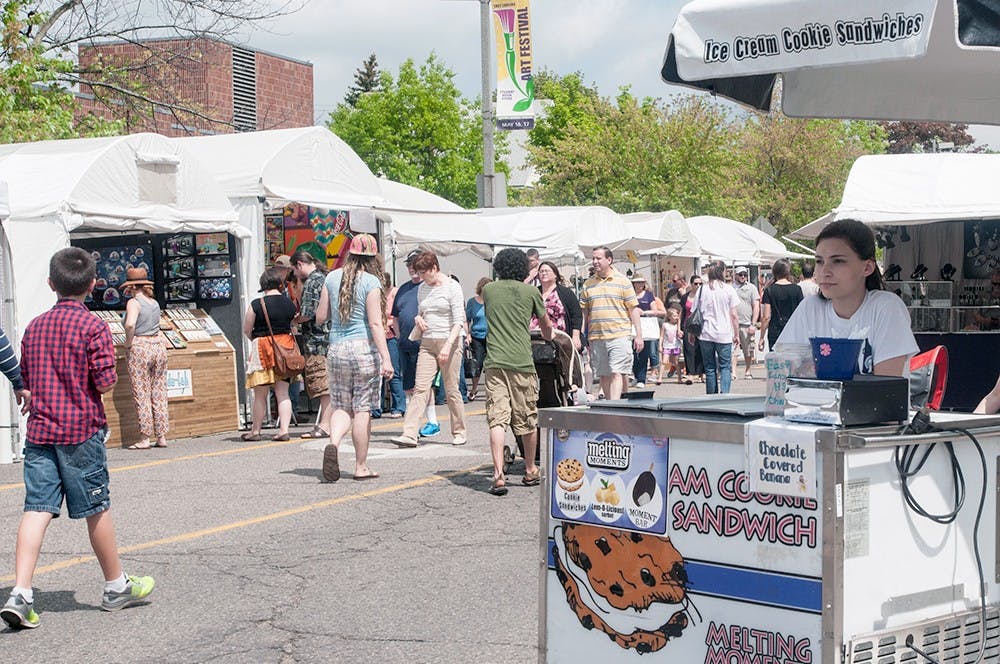 <p>Lansing resident Lily Churchill sells ice cream to festival attendees  on May 17, 2015, at the East Lansing Art Festival. Asha Johnson/The State News</p>