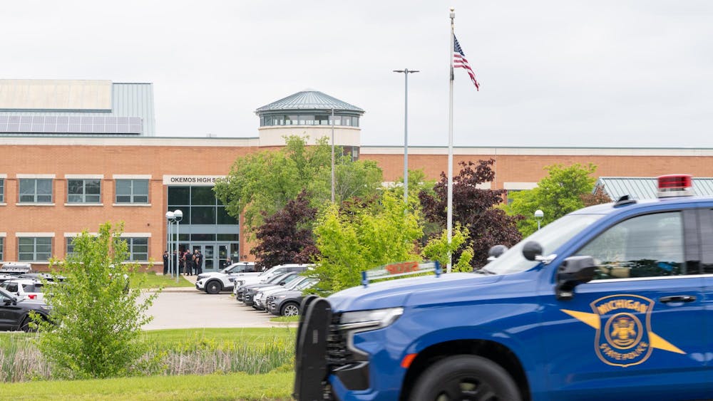 Police officers gather following a "preventative lockdown" outside of Okemos High School on May 29, 2025. 
