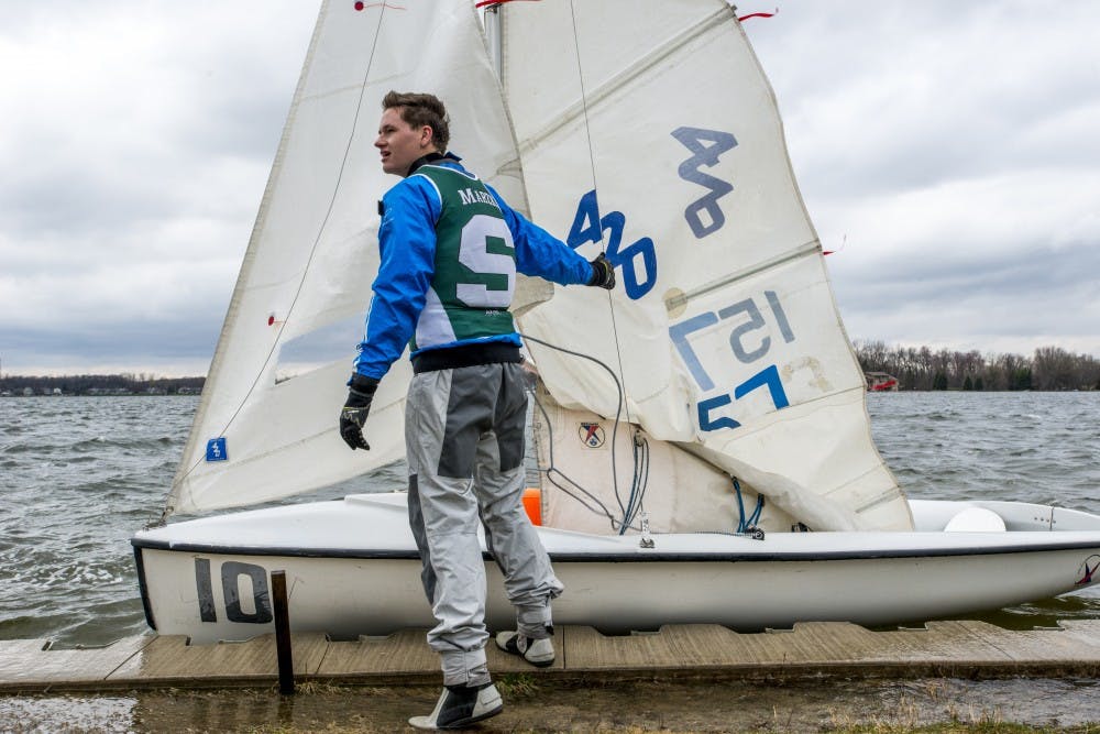 Construction management freshman Noah Marzke holds his sailboat in place before departing during the MSU Sailing Team practice on April 11, 2017 at Lake Lansing in Haslett, Mich. The MSU Sailing Team practices on the lake twice a week and competes against other schools in a regatta every weekend.