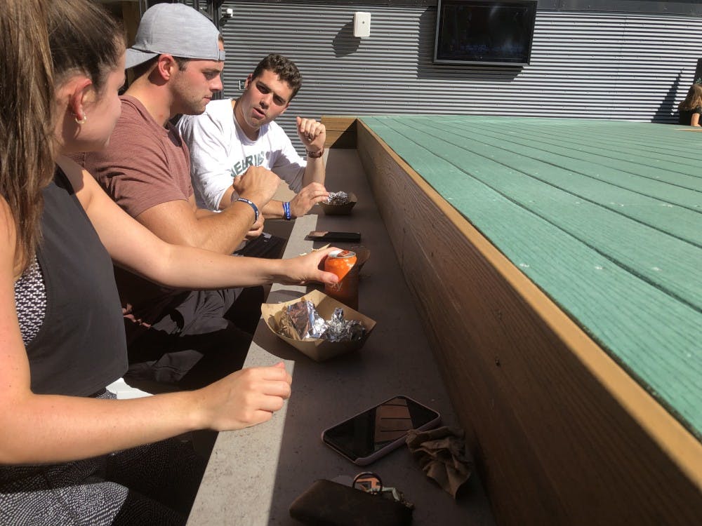 <p>Alexandra Gormely, Tate Macodnald and Zach Tearson enjoy tacos from Barrio at the taste testing for Landmark residents.</p>