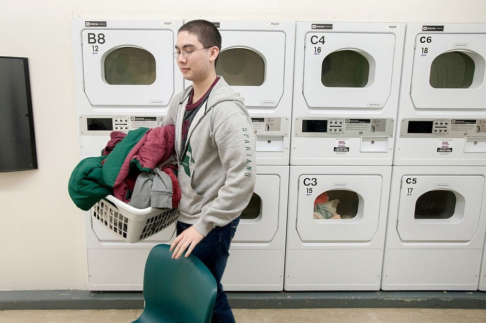 	<p>Studio art sophomore Chris Marshall prepares to dry his laundry Jan. 6, 2013, in the basement of McDonel Hall. Laundry in residence halls will become completely free in Fall 2013 semester, with Snyder and Phillips halls leading the change this summer. Justin Wan/The State News</p>
