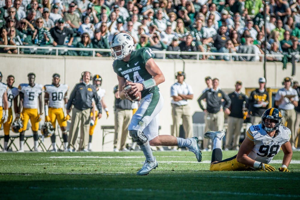 Sophomore quarterback Brian Lewerke (14) runs the ball during the game against Iowa on Sept. 30, 2017, at Spartan Stadium. The Spartan defeated the Hawkeyes, 17-10.