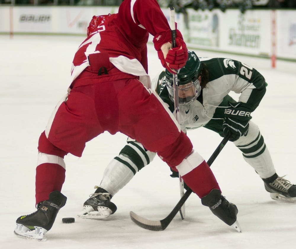 <p>Then, sophomore forward Michael Ferrantino faces off against Wisconsin forward Nic Kerdiles on March 15, 2014, at Munn Ice Arena. The Spartans were defeated by the Badgers, 4-3. Danyelle Morrow/The State News</p>