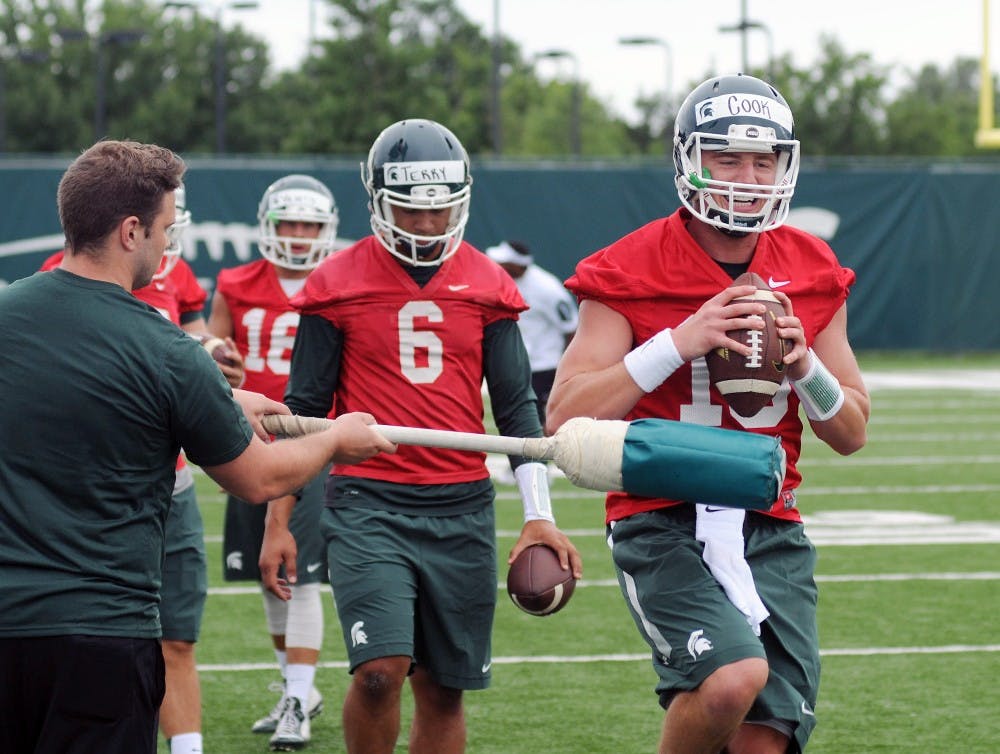 <p>Senior starting quarterback Connor Cooks completes football drills next to the Duffy Daugherty Football Building on August 8, 2015 during the first football practice of fall. Joshua Abraham/The State News</p>