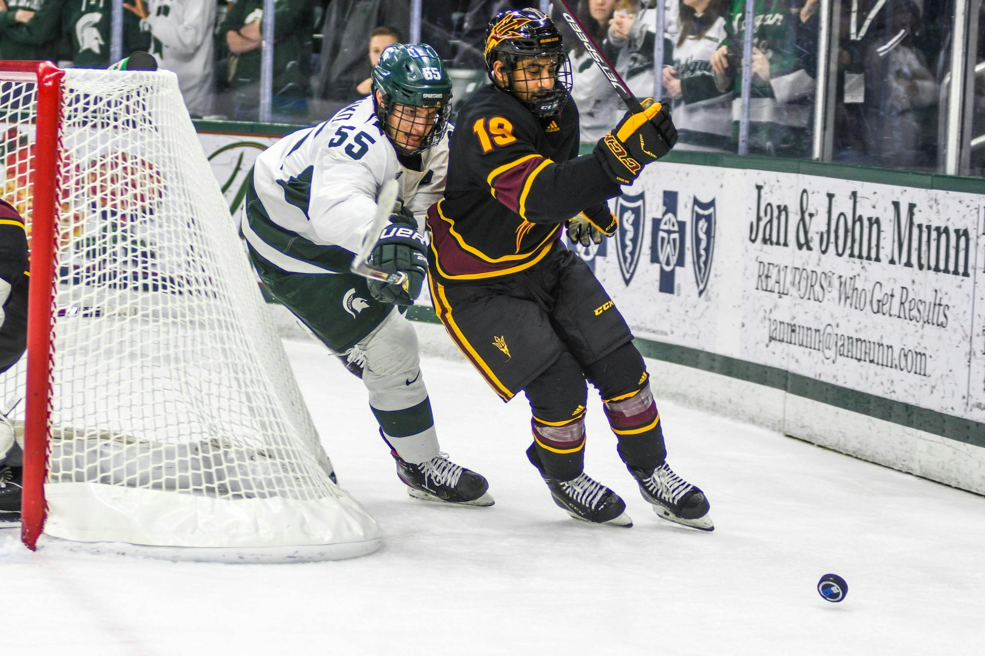 Senior center Patrick Khodorenko (55) fights for the puck during the game against Arizona at the Munn Ice Arena on Dec. 14, 2019. The Sun Devils defeated the Spartans, 4-3.