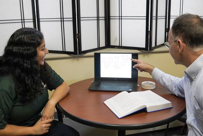 Ph.D. student Camila Alvayay and Professor Mark Skidmore looking over a map of Detroit at Morrill Hall of Agriculture on Sept. 20, 2022. 