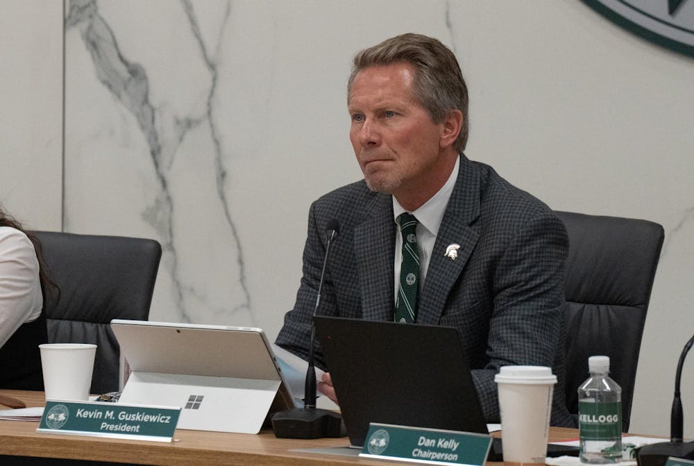 Michigan State University President Kevin Guskiewicz listens to Brenda Tracy's comments during a board meeting at the Hannah Administration building on Oct. 25, 2024.