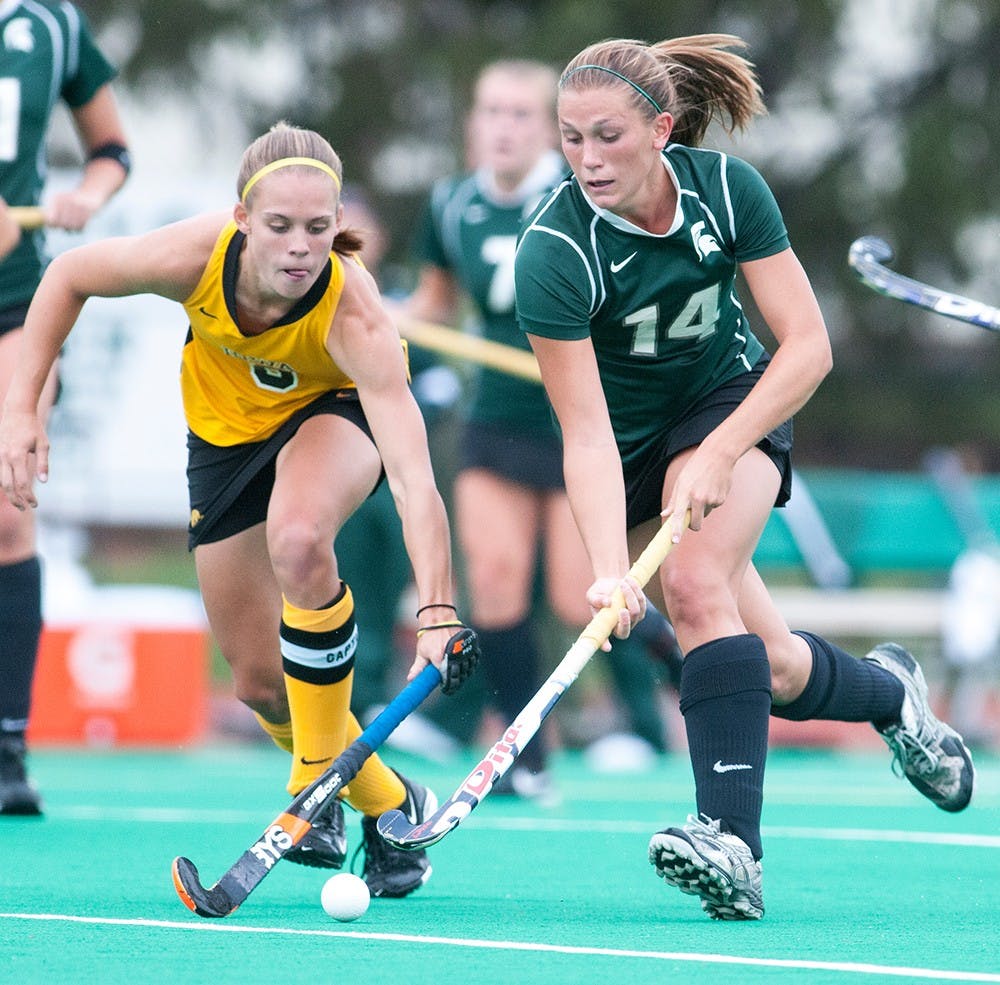 	<p>Junior midfielder Katherine Jamieson, No. 14, moves ahead with Iowa midfielders and backs Jessica Barnett next to her. The Hawkeyes defeated the Spartans, 1-0, on Friday, Sept. 21, 2012 at Ralph Young Field. Justin Wan/The State News</p>