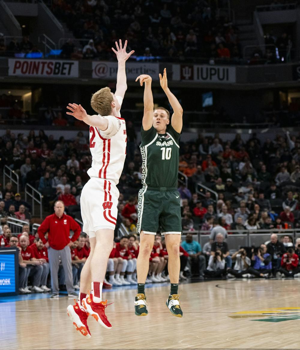 <p>Redshirt senior Joey Hauser (10) shoots a three-pointer for Michigan State in their match against the Wisconsin Badgers in the quarter-finals of the B1G Tournament at Gainbridge Fieldhouse in Indianapolis, Indiana. - March 11, 2022. </p>
