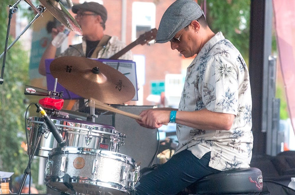 <p>Drummer Jose Espinosa plays with Agunanko on August 1, 2014, at Lansing JazzFest. Due to technical issues involving the rain earlier in the day, the band did not get to go on stage until well after their scheduled time. Jessalyn Tamez/The State News</p>