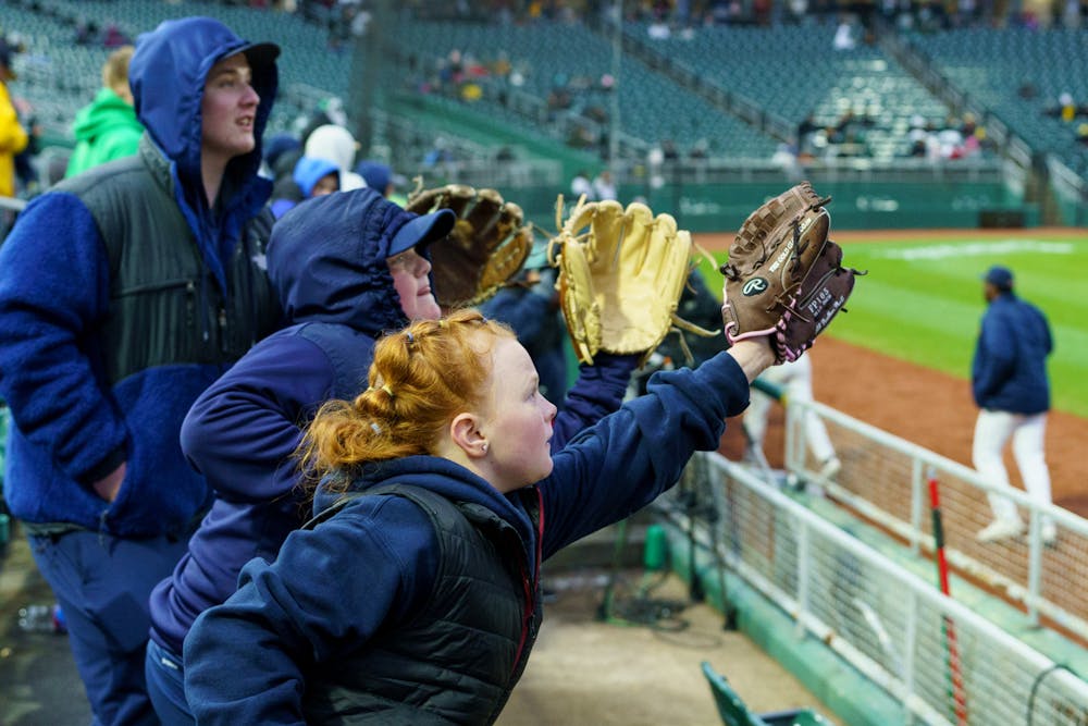 <p>Michigan fans call out for the ball after a foul ball was hit and reach with concentration as they try to catch the ball. Michigan State lost 18-6 to Michigan on April 15, 2022 at the Lugnut Stadium.</p>