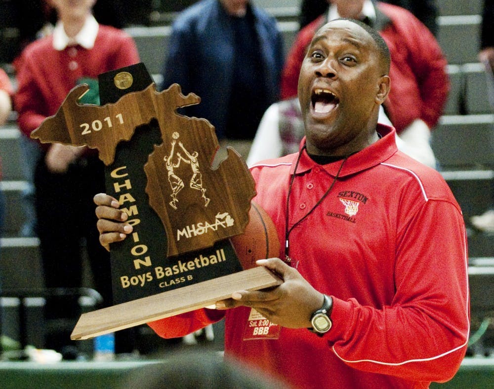 Lansing Sexton coach Carlton Valentine accepts the MHSAA Class B Boys Basketball Champion trophy Mar. 2011 at Breslin Center. Valentine is the father and former coach of senior forward Denzel Valentine.