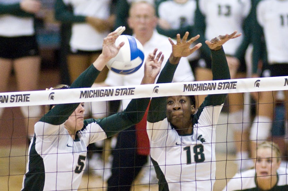 Senior outside hitter Jenilee Rathje, left, and sophomore middle blocker Alexis Mathews attempt to block a shot Saturday at Jenison Field House. The Spartans defeated the Iowa Hawkeyes 3-0. Matt Radick/The State News