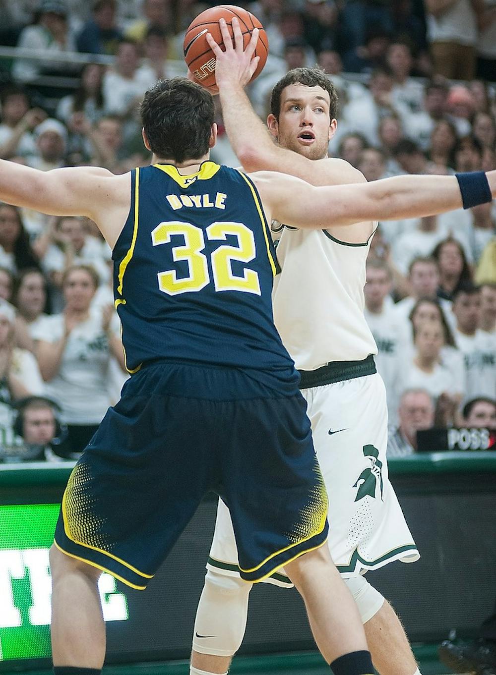 <p>Junior forward Matt Costello looks to pass past Michigan forward Ricky Doyle Feb. 2, 2015, during the game against Michigan at Breslin Center. The Spartans defeated the Wolverines in overtime, 76-66. Alice Kole/The State News</p>