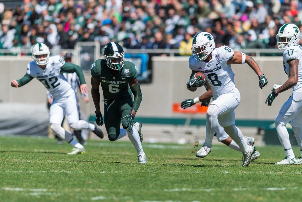 Sophomore wide receiver Jalen Nailor (8) runs from senior safety David Dowell (6). The green team beat the white team, 42-26, in the MSU Spring football game at Spartan Stadium on April 13, 2019. 