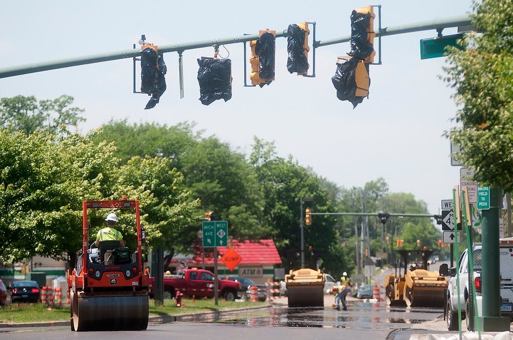 	<p>Workers on rollers smooth out asphalt on the repaved Grand River Avenue on June 14, 2013. Some of the rollers are designed to smooth out the marks in the asphalt, while others help compact it. Julia Nagy/The State News</p>