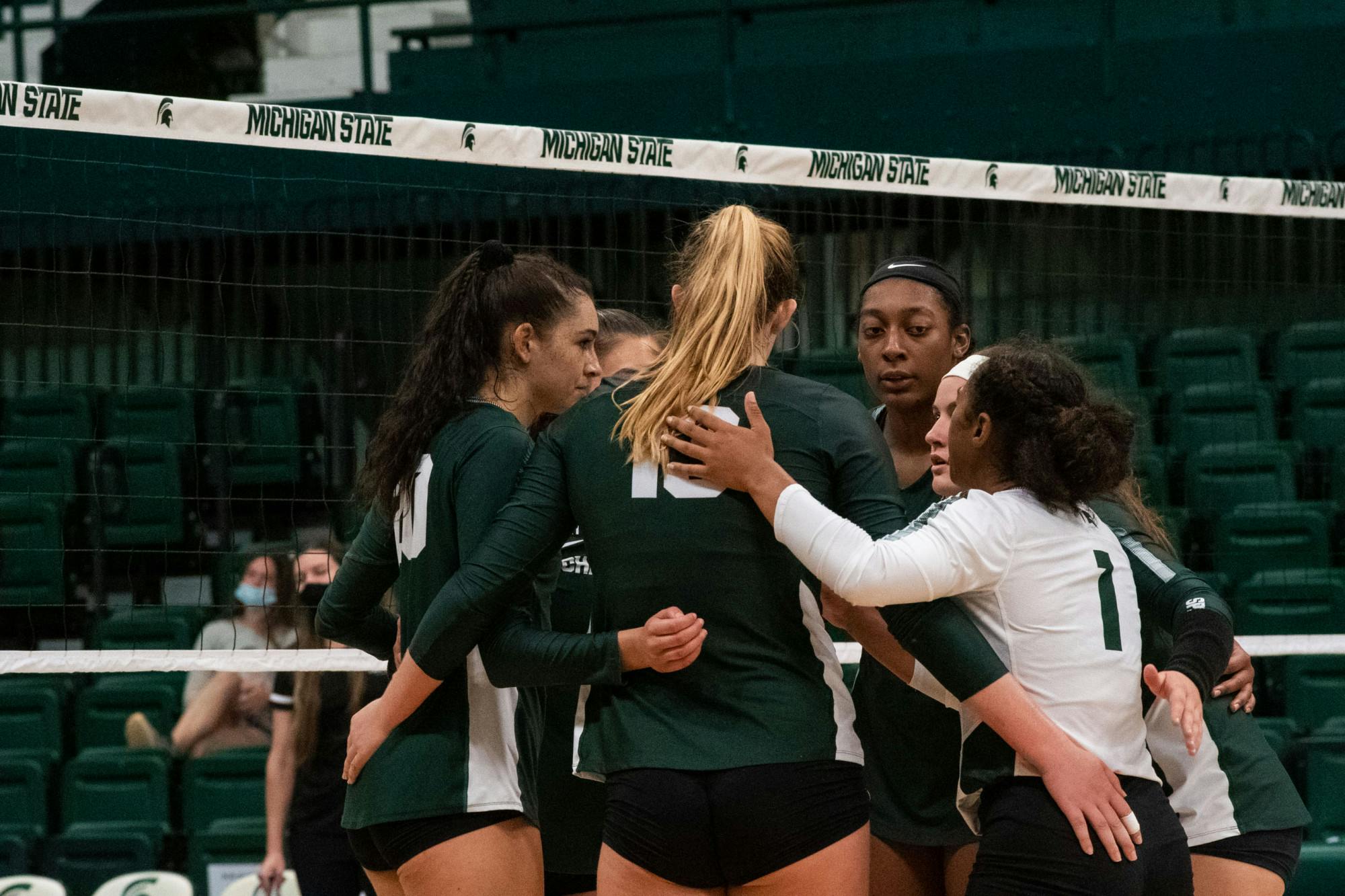 <p>Michigan State Volleyball teams join in a huddle during their game against IUPUI on Sept.18, 2021. </p>