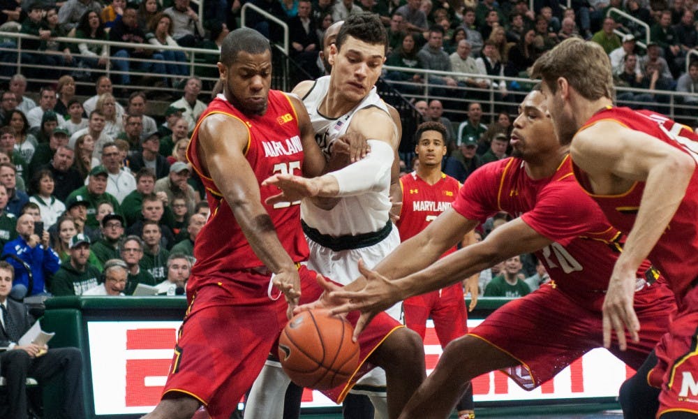 Sophomore forward Gavin SChilling fights for a rebound with Maryland forward Damonte Dodd, left, and guard Richaud Pack during the game against Maryland on Dec. 30, 2014, at Breslin Center. The Spartans were defeated by the Terrapins, 68-66 in double overtime. Danyelle Morrow/The State News