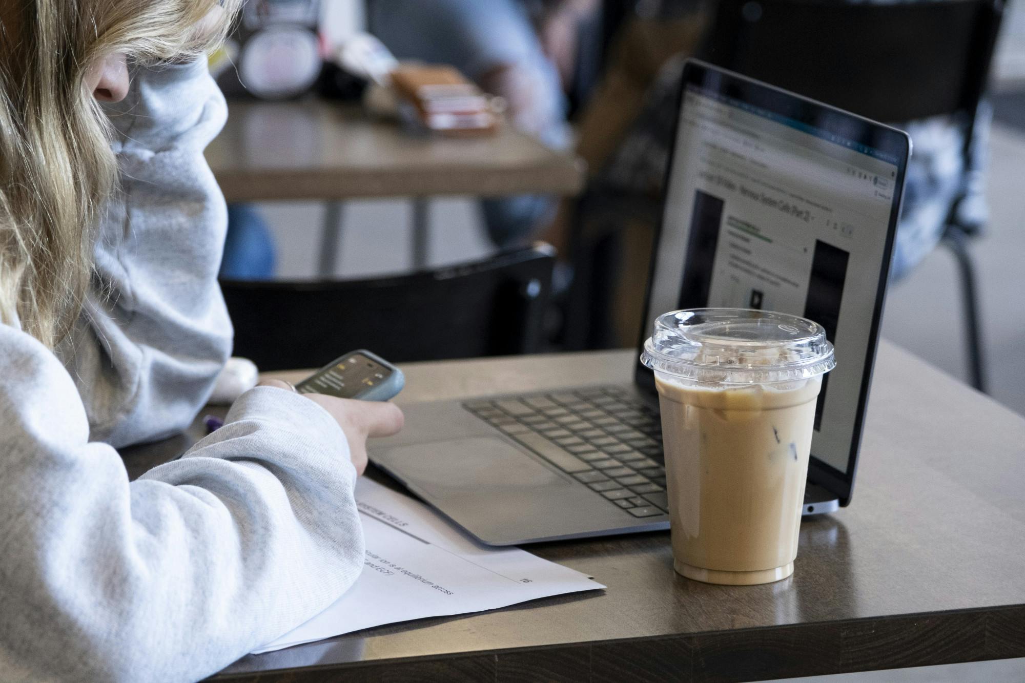 <p>A person with an iced coffee at Foster Coffee Company in East Lansing on Sept. 30, 2021.</p>