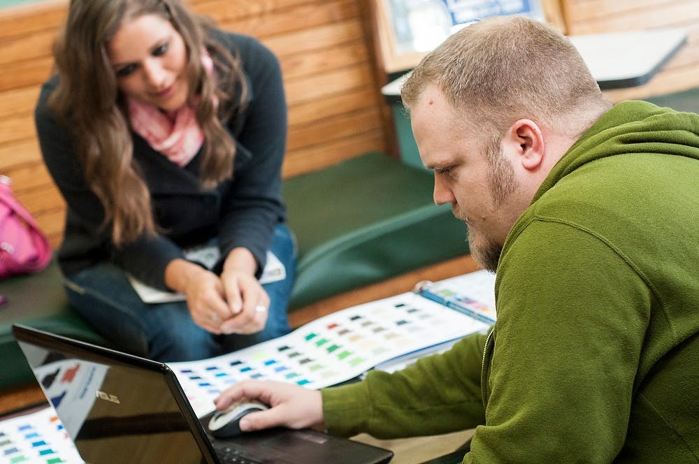 	<p>Michigan Shirtworks owner Ted Wilson helps agricultural business sophomore Hayleigh Geurink with an order Oct. 7, 2013 at his store on Grand River Avenue. The store recently opened in September.</p>