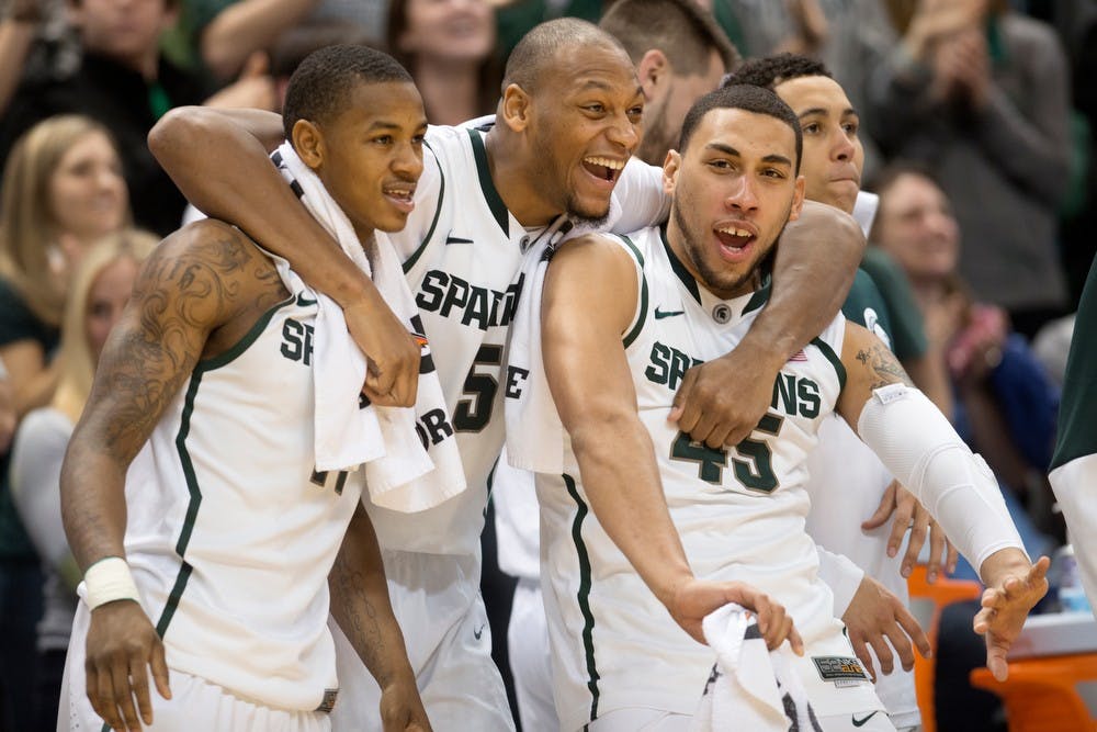 	<p>From left to right senior guard Keith Appling, senior forward Adreian Payne and sophomore guard Denzel Valentine celebrate the win against New Orleans on Dec. 28, 2013, at Breslin Center. The Spartans defeated the Privateers, 101-48. Julia Nagy/The State News</p>