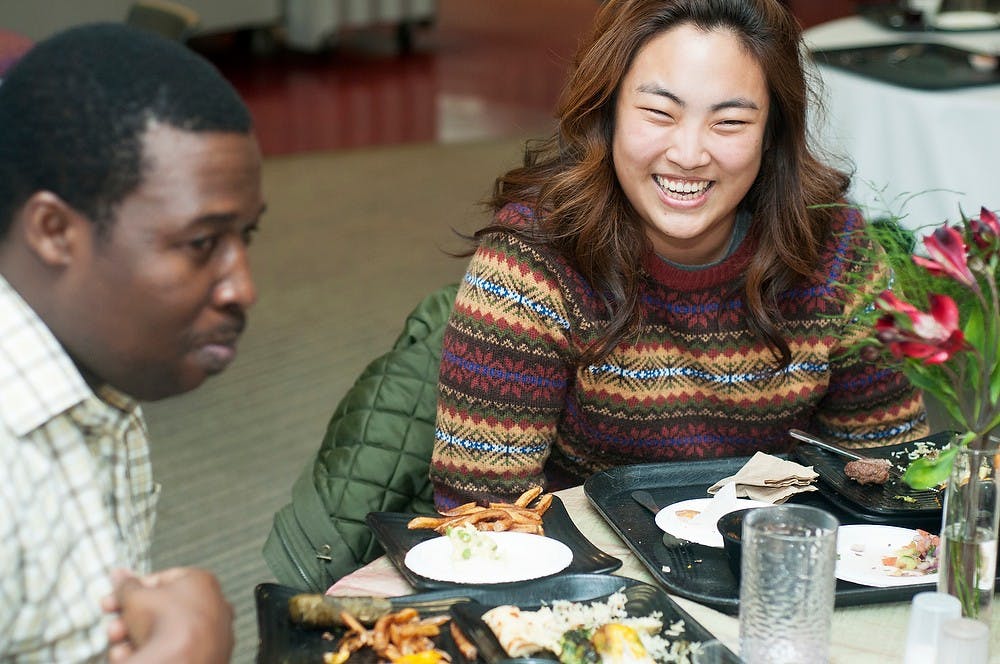 <p>Graduate students Boram Koo and Ibrahim Kanda share a laugh during Nowruz, the Persian New Year, on March 20, 2014, at Holmes Dining Hall. The New Year marks the first day of spring and was celebrated with food and traditional music for all to experience. Danyelle Morrow/The State News</p>