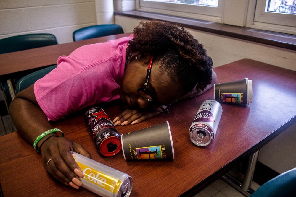 <p>Photo illustration. Psychology and criminal justice senior Brianna Harris rests her head on a desk on Oct. 10, 2018, at Berkey Hall. Balancing work, school and a social life is a challenge for many college students and often results in sleep deprivation.</p>