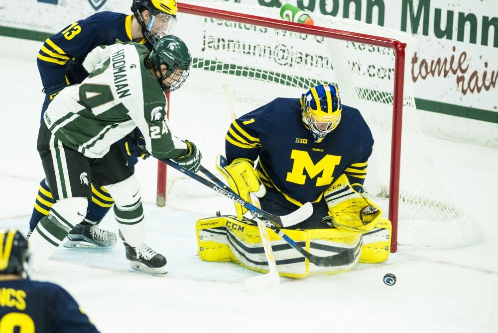 Senior forward Justin Hoomaian takes a shot against Michigan goaltender Steve Racine during the third period of the game against Michigan on Jan. 8, 2016 at Munn Ice Arena. The Spartans were defeated by the Wolverines 9-2. 