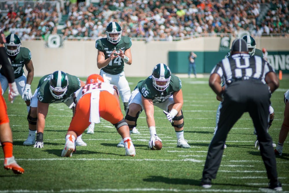 <p>Senior offensive lineman Brian Allen (65) prepares to snap the ball to redshirt sophomore quarterback Brian Lewerke (14) during the game against Bowling Green on Sep. 2, 2017, at Spartan Stadium. The Spartans defeated the Falcons, 35-10.</p>