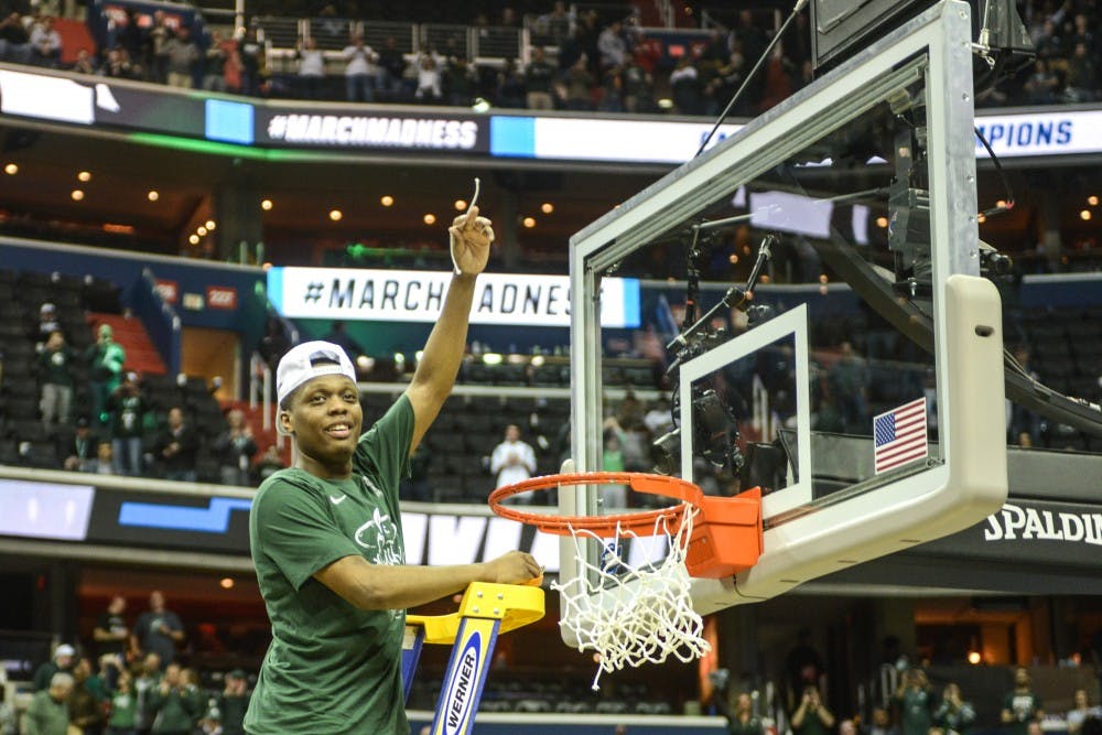 Junior guard Cassius Winston (5) cuts a piece from the net after the game against Duke at Capital One Arena on March 31, 2019. The Spartans defeated the Blue Devils, 68-67. The Spartans are the East Regional Winners and are headed to the Final Four.