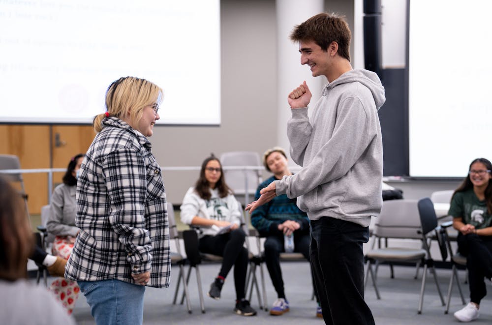 An MSU student and an intercultural aid play "rock, paper, scissors" as an icebreaker at the start of the weekly roundtable discussion at the Wonders Hall Kiva on Oct. 18, 2022. 