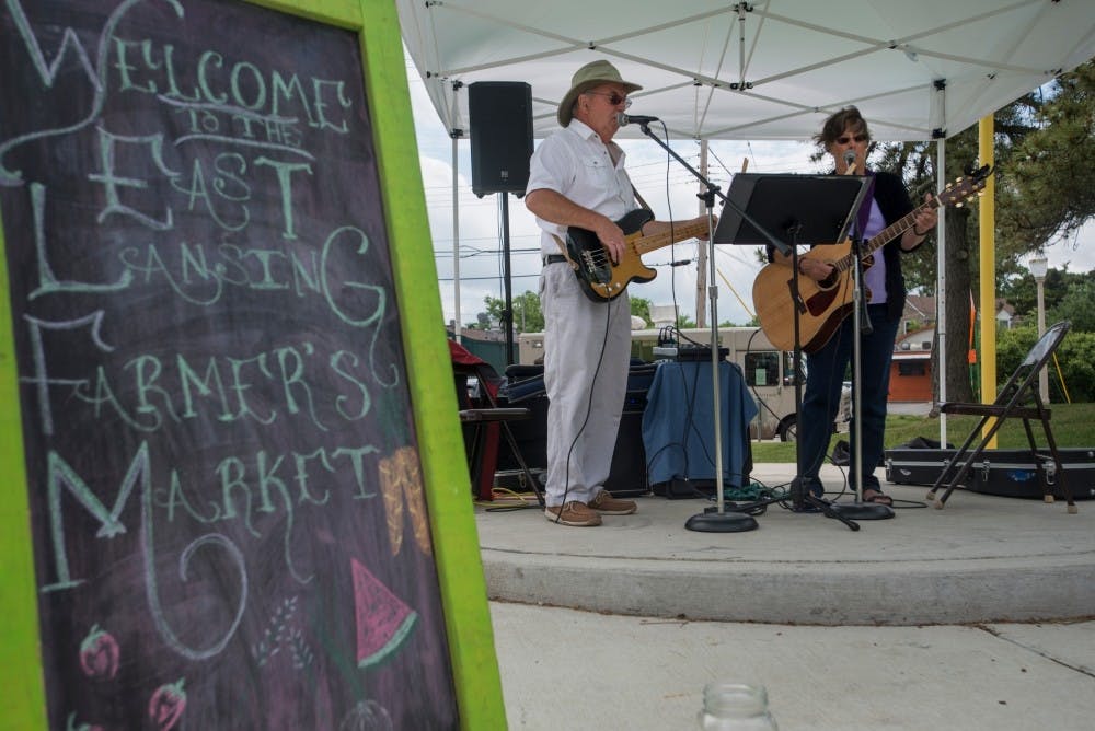 <p>Lyons, Mich. residents Billy Trommater, left, and Pat Trommater play music on June 5, 2016 at the Farmer's Market at Valley Court Park in East Lansing. Every food sold by vendors at the East Lansing Farmer's Market is 100% homegrown. Vendors must grow their own produce or make their own products. <strong>Photo by Nic Antaya.</strong><br>
</p>
