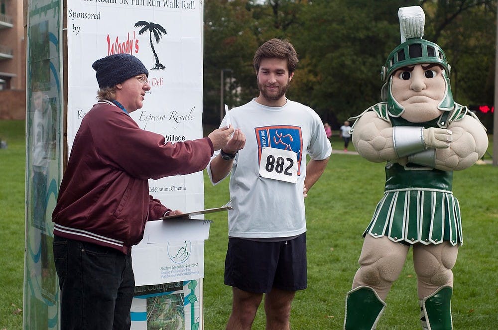 	<p>Volunteer Phillip Lamoureux hands packaging senior Kevan Farrell a gift card after placing fourth in a 5K to raise money for a dome to house a tropical garden. Cayden Royce/The State News</p>