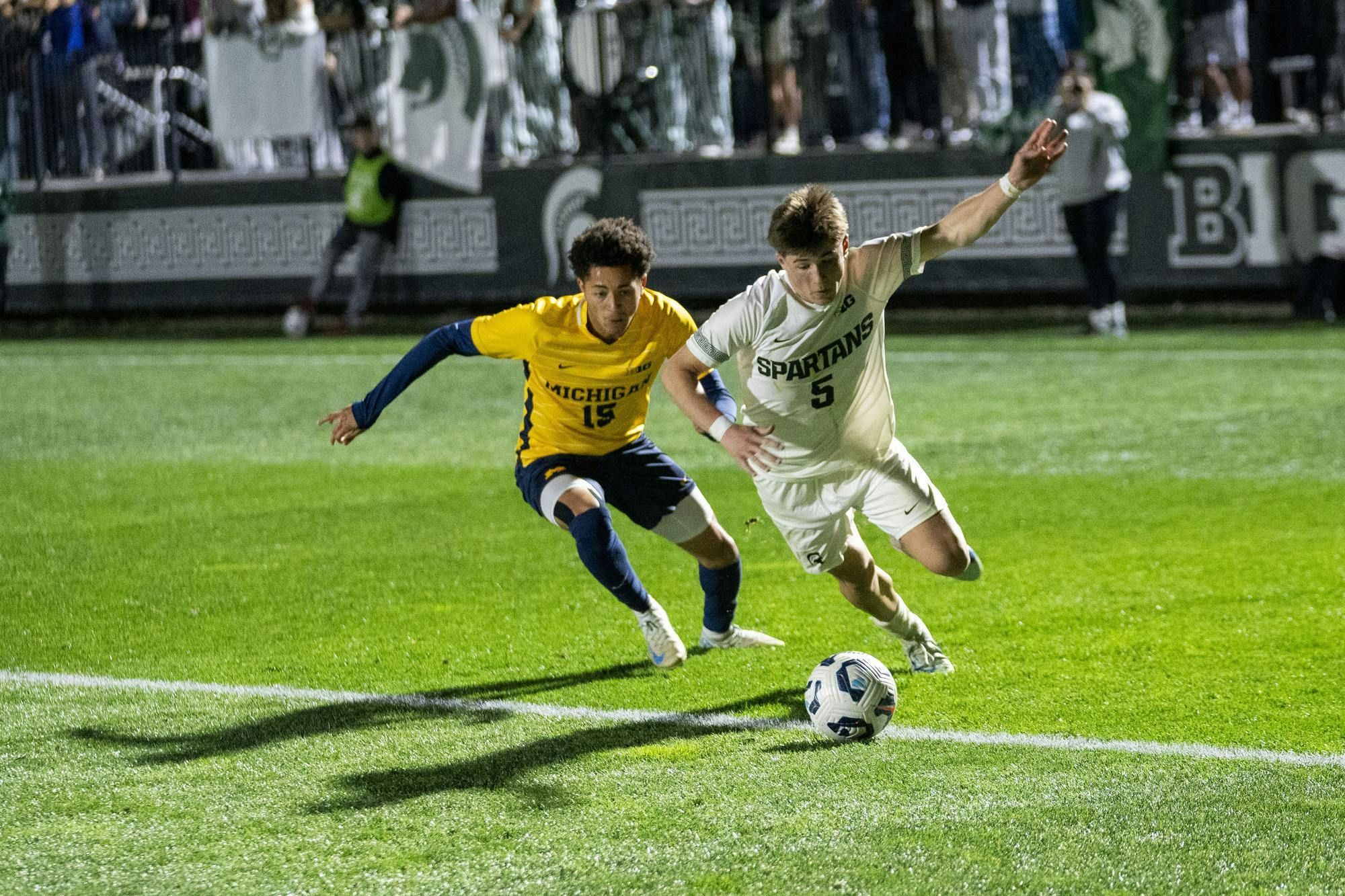 <p>Michigan State University freshman defender Brandon Munson (5) and University of Michigan junior forward Oliver Martin (15) run after the ball during the MSU vs. UOM men’s soccer match at DeMartin Stadium on Oct. 22, 2024.</p>