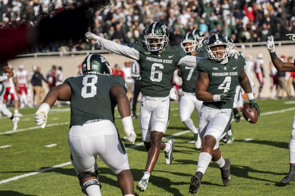 Conerback Ameer Speed (6) and defendive end Jacoby Windmon (4) celebrate after a touchdown during the game against Wisconsin on October 15, 2022. 