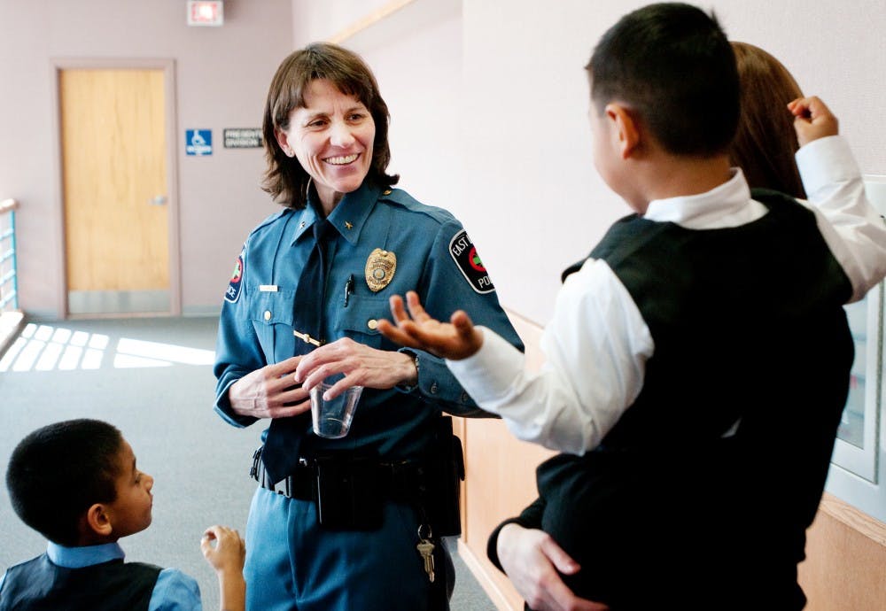 While her sons, Julian, 6, right, and Alex, 4, left, patiently wait, new East Lansing police Chief Julie Liebler, talks with Veronica Balash after being sworn in on Thursday afternoon at City Hall, 410 Abbot Road. Liebler joined the force in 1987 and was named as the replacement of predecessor Tom Wibert, who retired in Oct. 2010. Josh Radtke/The State News