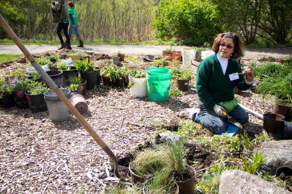 <p>Anita Calcagno, a master gardener at Fenner Nature Center reads out the name of a plant written on a stick Sunday afternoon at Fenner Nature Center. Earth Day Extravaganza was put on with the help of Fenner Nature Center, the FW Graduate Student Organization, and several other MSU student groups. Aaron Snyder/The State News. </p>