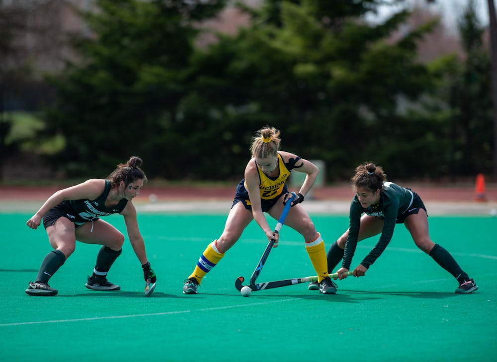 Michigan senior Halle O'NeilL fights for possession during an away game against MSU on April 2, 2021.