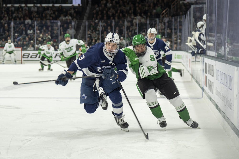 <p>Michigan State forward Griffin Jurecki (12) and Penn State defender Casey Aman (3) race for the puck at Munn Ice Arena on Feb. 21, 2025.</p>