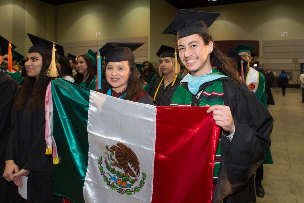 Attendees of the 2018 Statewide Hispanic/Latino College Graduation Ceremony hold up a Mexican flag during the event at the Lansing Center April 6, 2018. Courtesy of the Michigan Department of Licensing and Regulatory Affairs.