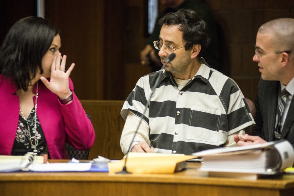 Defense attorney Shannon Smith whispers to her client, former MSU employee Larry Nassar, during the preliminary examination on Feb. 17, 2017 at 55th District Court in Mason, Mich. The preliminary examination occurred as a result of former MSU employee Larry Nassar's alleged sexual abuse.